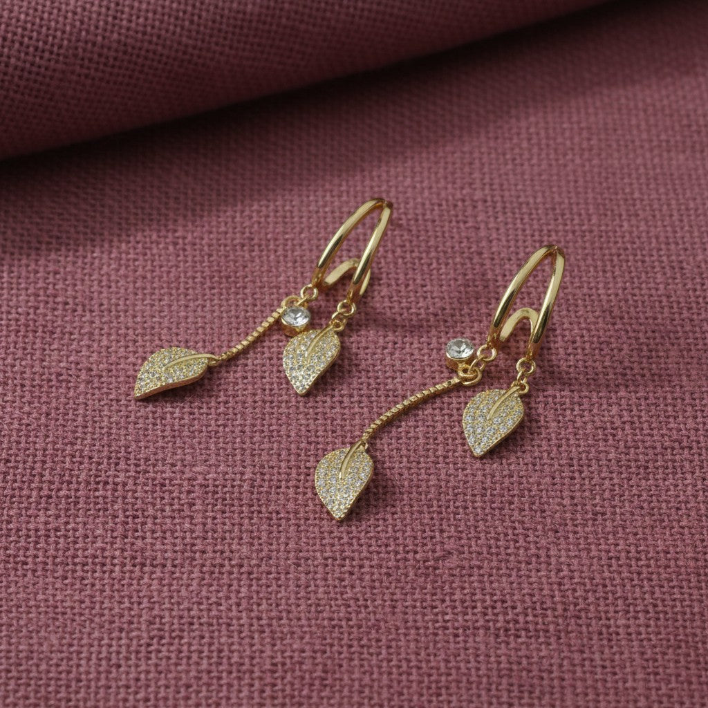 SVORA gold-plated stainless steel dangle earrings with leaf-shaped charms and clear crystals.