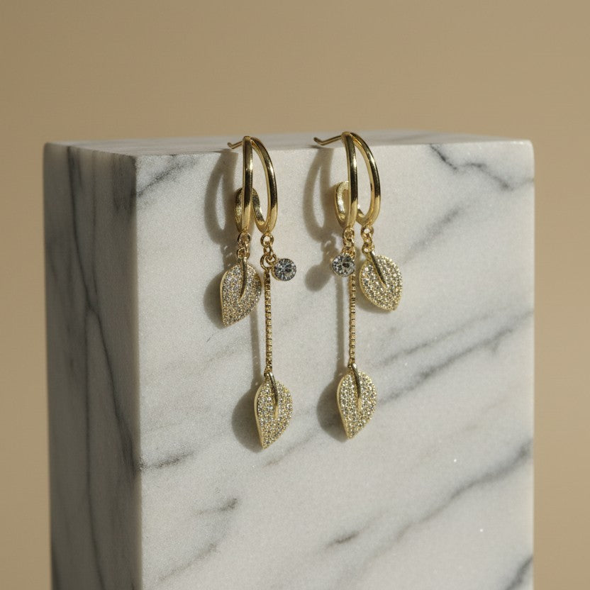 SVORA gold-plated stainless steel dangle earrings with pave crystal leaf charms and round crystal studs.