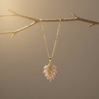 SVORA gold leaf pendant necklace with pink marquise CZ stones and white CZ accents on a delicate chain.