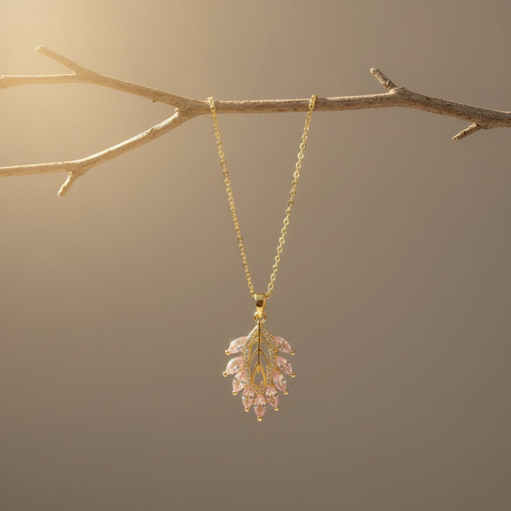 SVORA gold leaf pendant necklace with pink marquise CZ stones and white CZ accents on a delicate chain.
