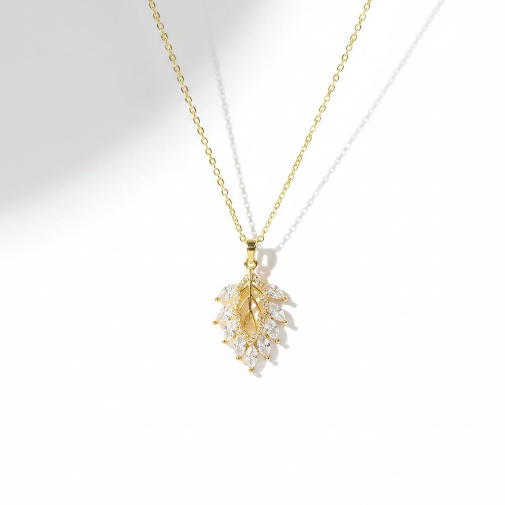 SVORA gold leaf cluster pendant with marquise CZ stones on a delicate chain. 18K gold plated stainless steel.