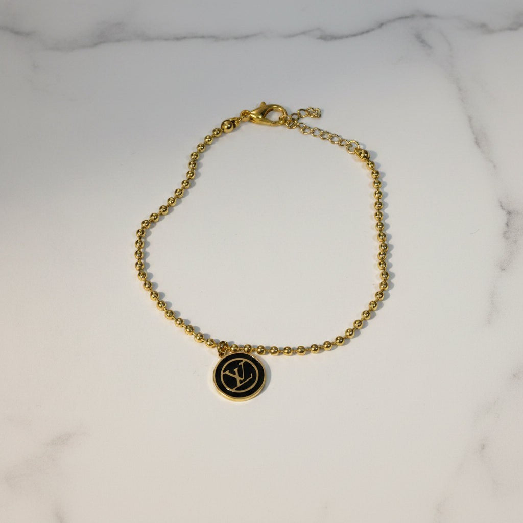 SVORA gold ball bead chain bracelet with black monogram disc, adjustable lobster clasp, 18K gold plated stainless steel.
