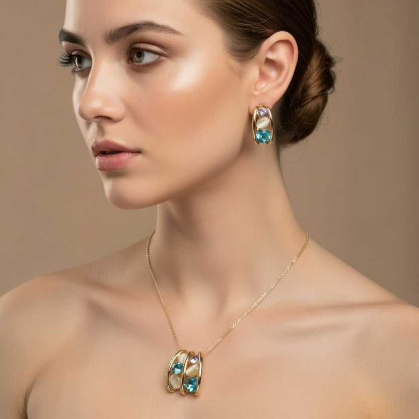 SVORA gold-tone necklace and earrings set with blue, lavender, and cream cabochon stones in a caged design.