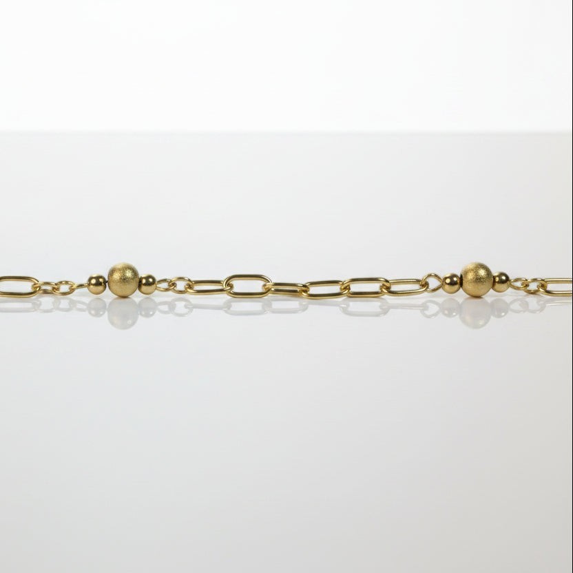SVORA gold paperclip chain bracelet with three small gold beads spaced along it. 18K gold plated stainless steel.