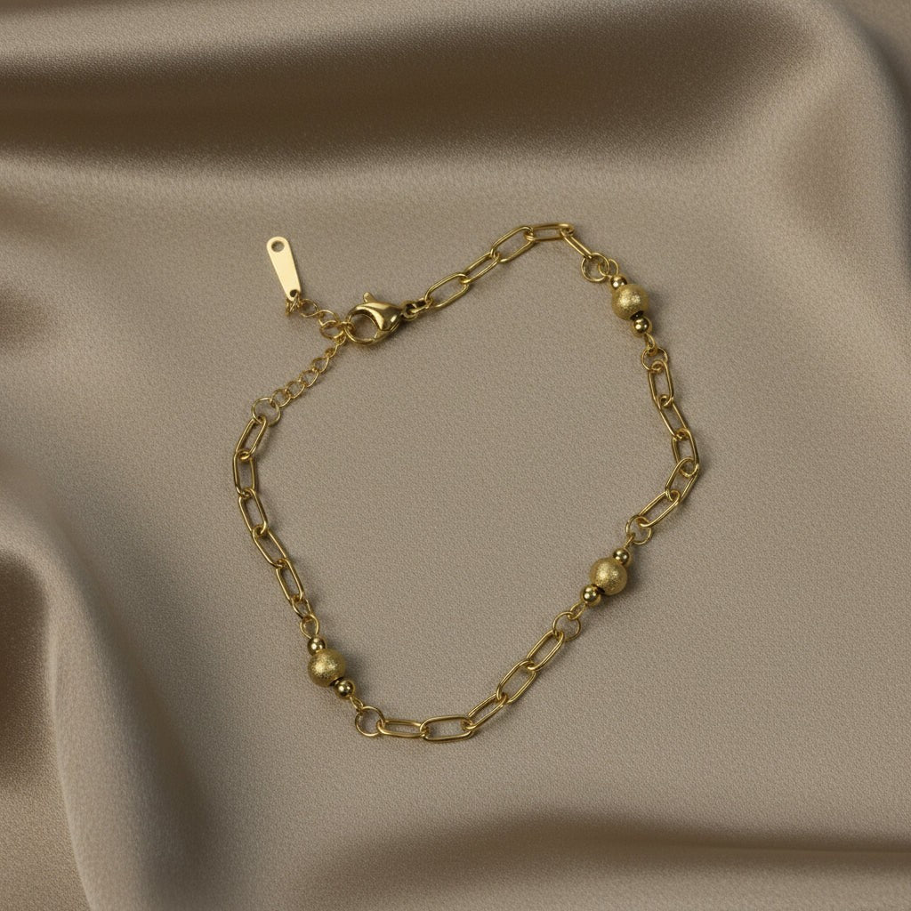 SVORA gold paperclip chain bracelet with spaced textured gold beads and lobster clasp. 18K gold plated stainless steel.
