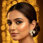 SVORA gold ribbon stud earrings with pavé cubic zirconia accents, featuring a sculptural design.