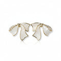 SVORA sculptural gold ribbon earrings with white stone inlay and pavé cubic zirconia accents.