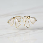 SVORA sculptural gold ribbon stud earrings with white stone and pavé cubic zirconia accents.