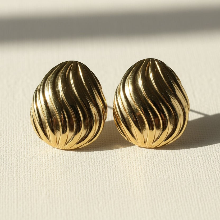 SVORA sculpted shell-dome gold stud earrings with ribbed surface detail and high polish finish.