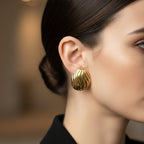 SVORA sculpted gold-tone shell dome stud earrings with ribbed surface detail and high polish finish.