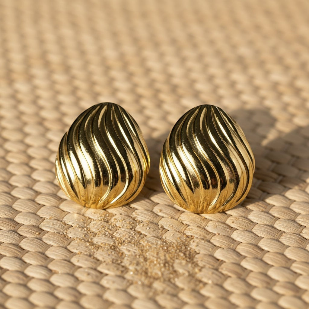 SVORA sculpted shell-dome gold stud earrings with ribbed surface detail and high polish finish.
