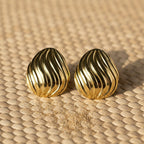 SVORA sculpted shell-dome gold stud earrings with ribbed surface detail and high polish finish.