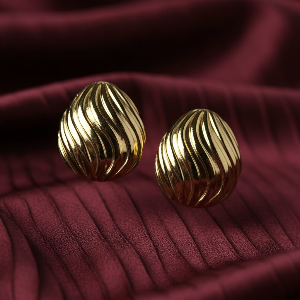 SVORA sculpted shell-dome gold stud earrings with ribbed surface detail and high polish finish.