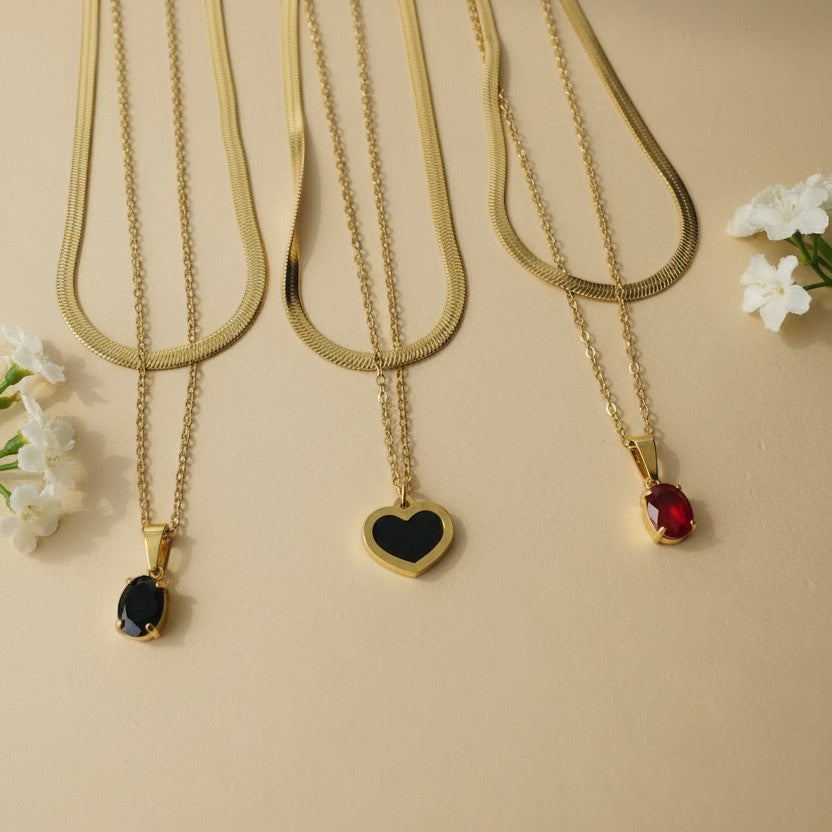 SVORA gold snake chain layered necklace with black enamel heart pendant and oval black stone pendant