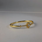 SVORA gold-plated stainless steel hinged bracelet with solitaire CZ center and milgrain detailing.