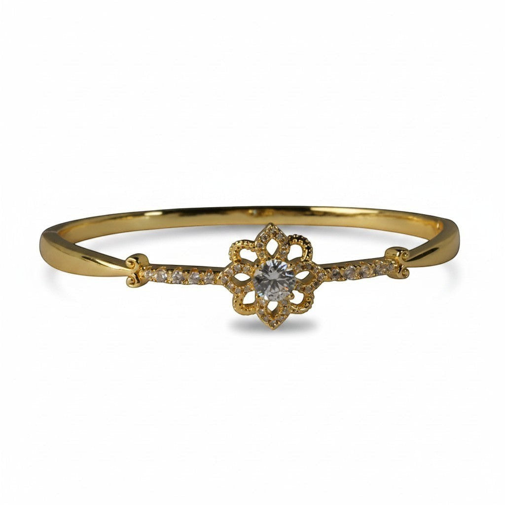 SVORA gold-plated stainless steel bracelet with a central flower design featuring a clear cubic zirconia and smaller stones on the band.