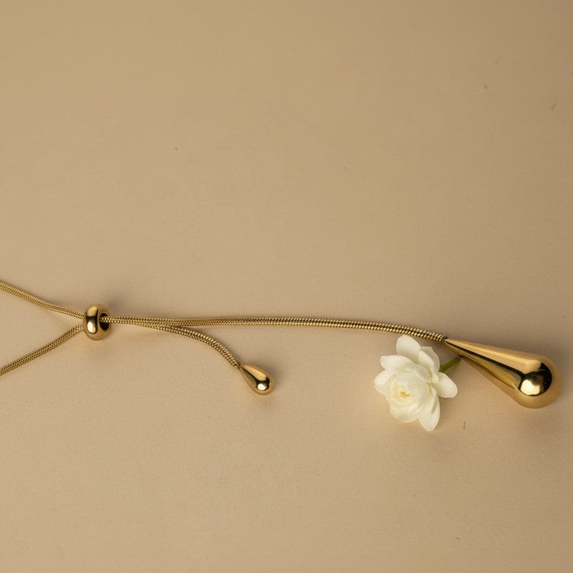 SVORA gold teardrop lariat necklace with adjustable snake chain and polished teardrop charms.