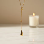 SVORA gold teardrop lariat necklace made of stainless steel with adjustable snake chain and polished charms.