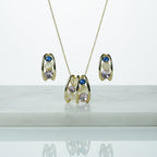 SVORA gold tone necklace and earrings set with pink, blue, and cream cabochon stones in a caged design.