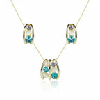 SVORA gold-tone necklace and earrings set with blue, lavender, and cream cabochon stones in a caged design.