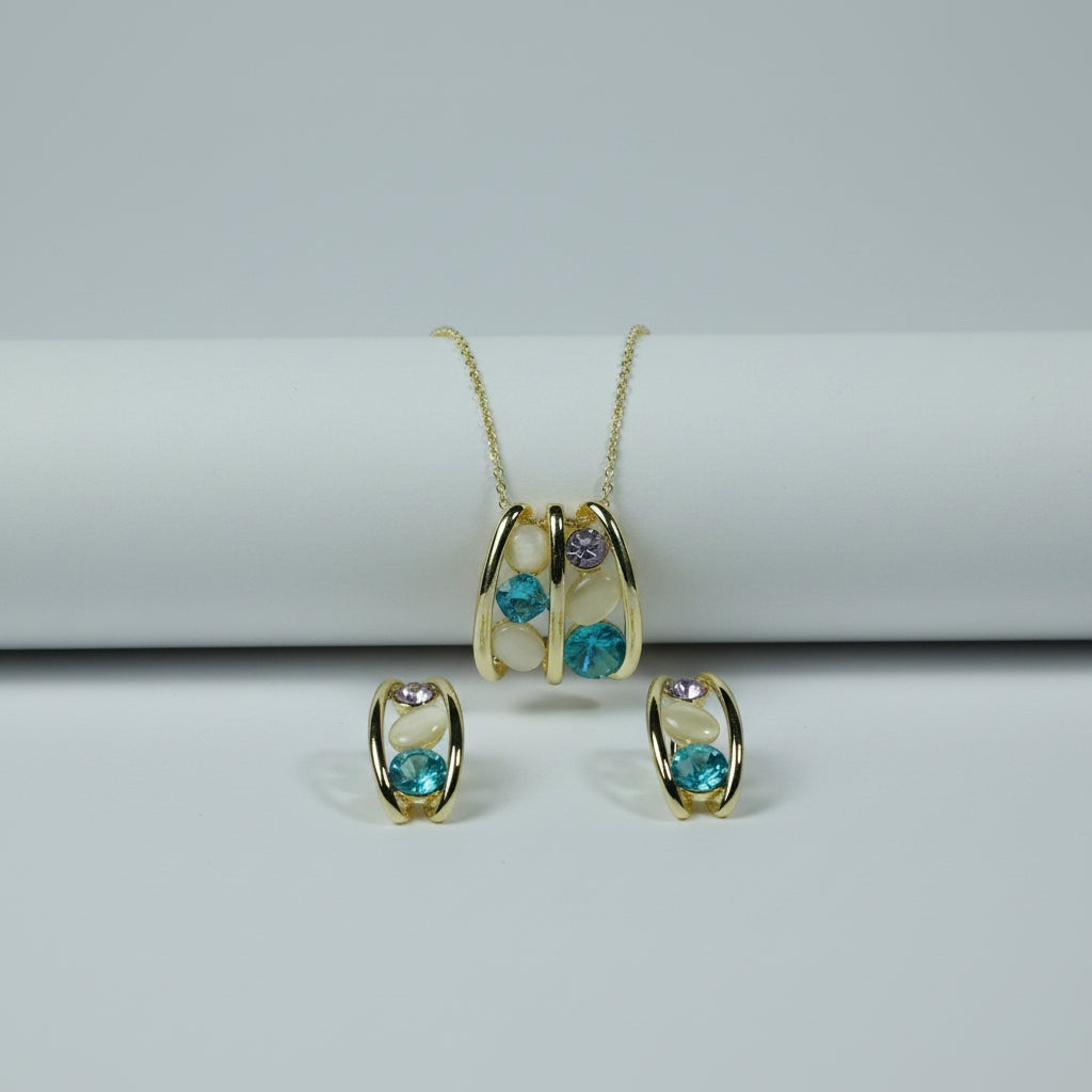 SVORA gold-tone necklace and earrings set with teal blue, lavender, and cream cabochon stones in a caged design.