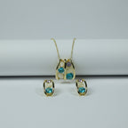 SVORA gold-tone necklace and earrings set with teal blue, lavender, and cream cabochon stones in a caged design.