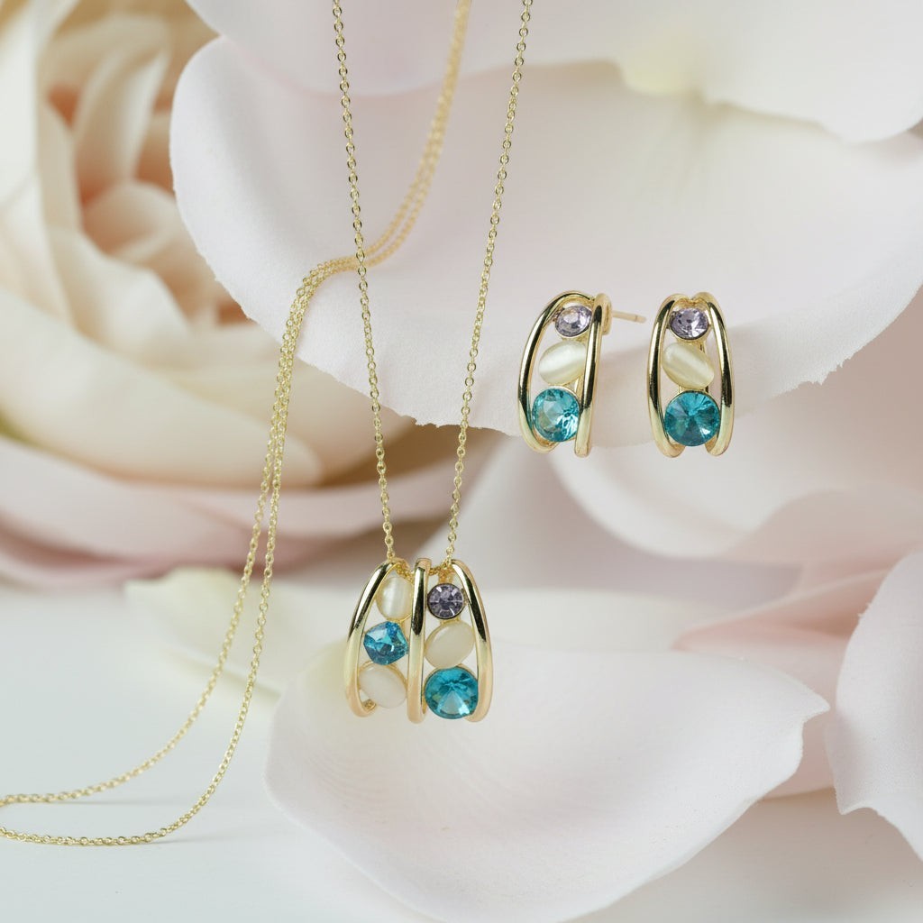 SVORA gold-tone necklace and earrings set with blue, lavender, and cream cabochon stones in a caged design.