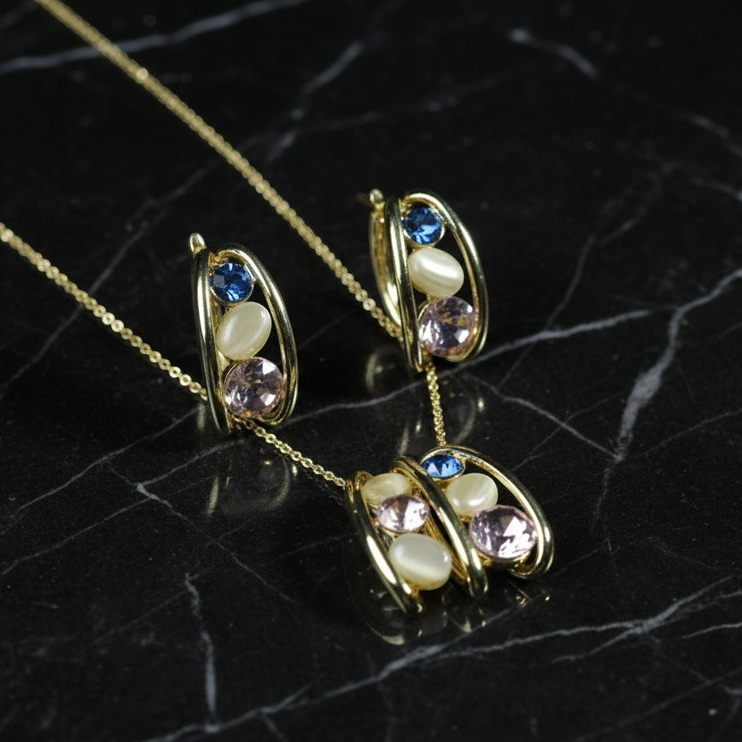SVORA gold tone necklace and earrings set with pink, blue, and cream stones. Stainless steel with 18K gold plating.