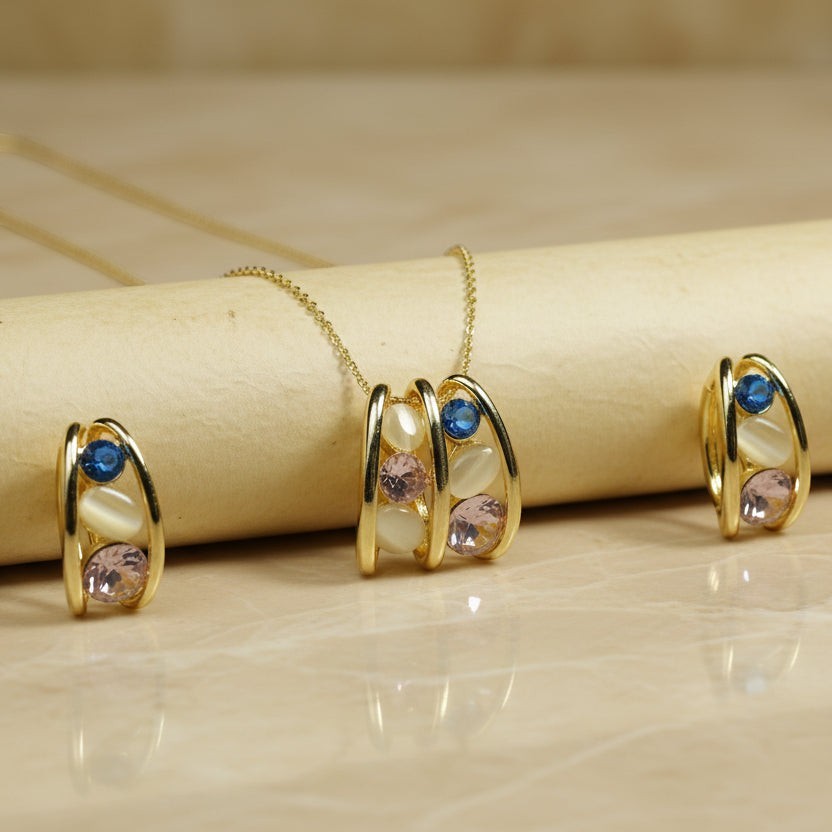 SVORA gold tone necklace and earrings set with pink, blue, and cream stones. Stainless steel, 18K gold plating.