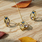 SVORA gold tone necklace and earrings set with pink, blue, and cream stones. Stainless steel with 18K gold plating.