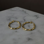 SVORA gold twisted hoop earrings with a polished finish and rounded silhouette, made of stainless steel.