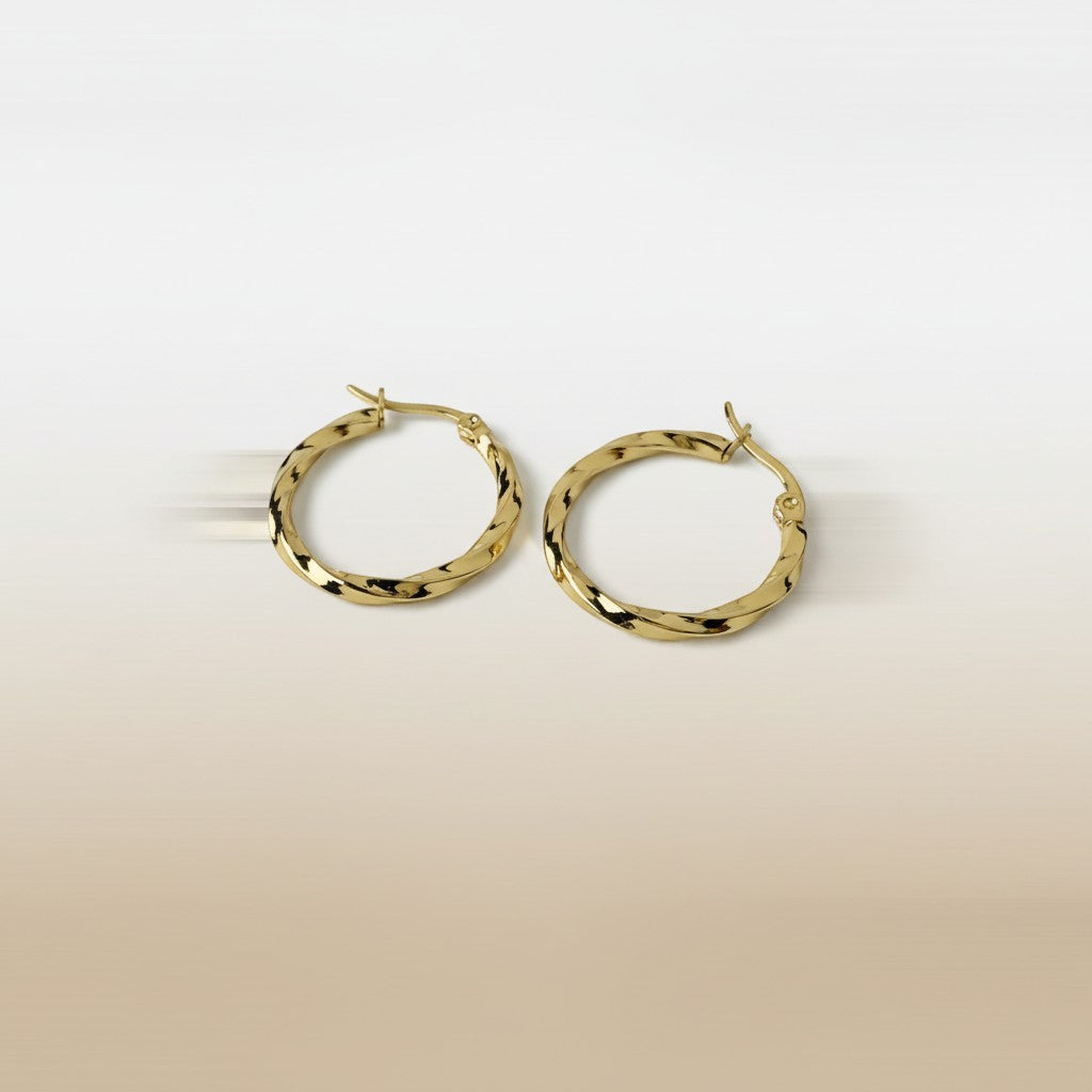 SVORA gold twisted hoop earrings with a polished finish and rounded silhouette. Textured detail adds contemporary style.