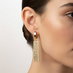 SVORA gold-tone stainless steel huggie hoop earrings with Greek key cut-out drop and pavé cubic zirconia.
