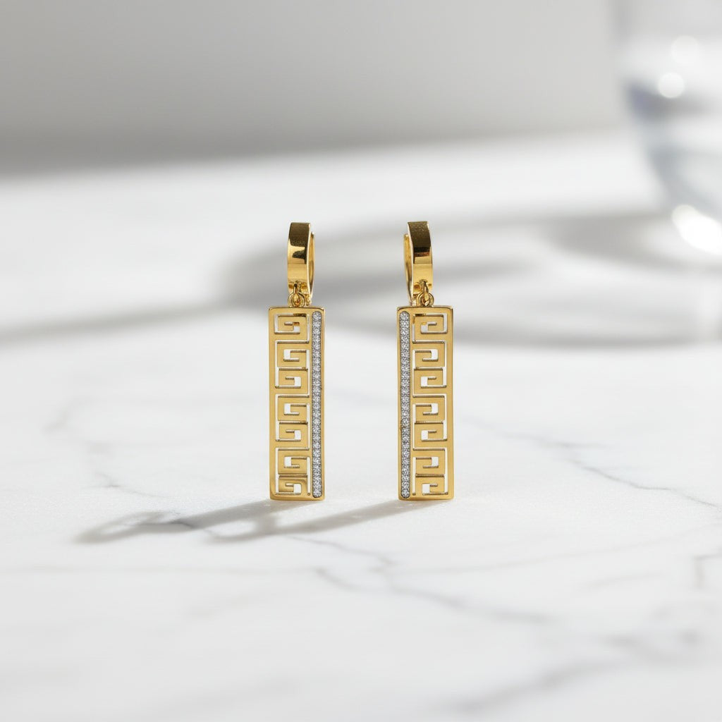 SVORA gold-tone stainless steel huggie hoop earrings with Greek key cut-out drop and pavé cubic zirconia.