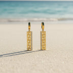 SVORA gold tone stainless steel huggie hoop earrings with Greek key cut-out drop and pavé cubic zirconia.
