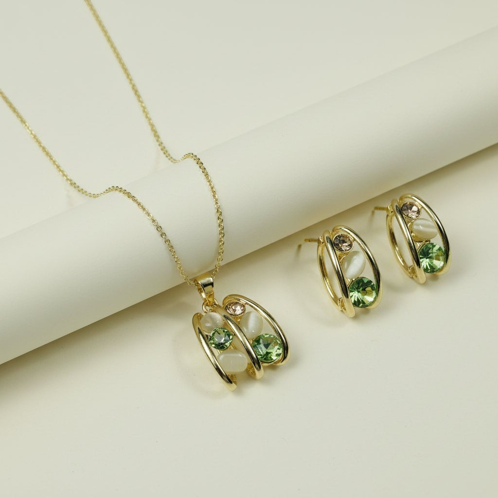 SVORA gold tone necklace and earrings set with emerald green, peach, and cream stones in a caged design.