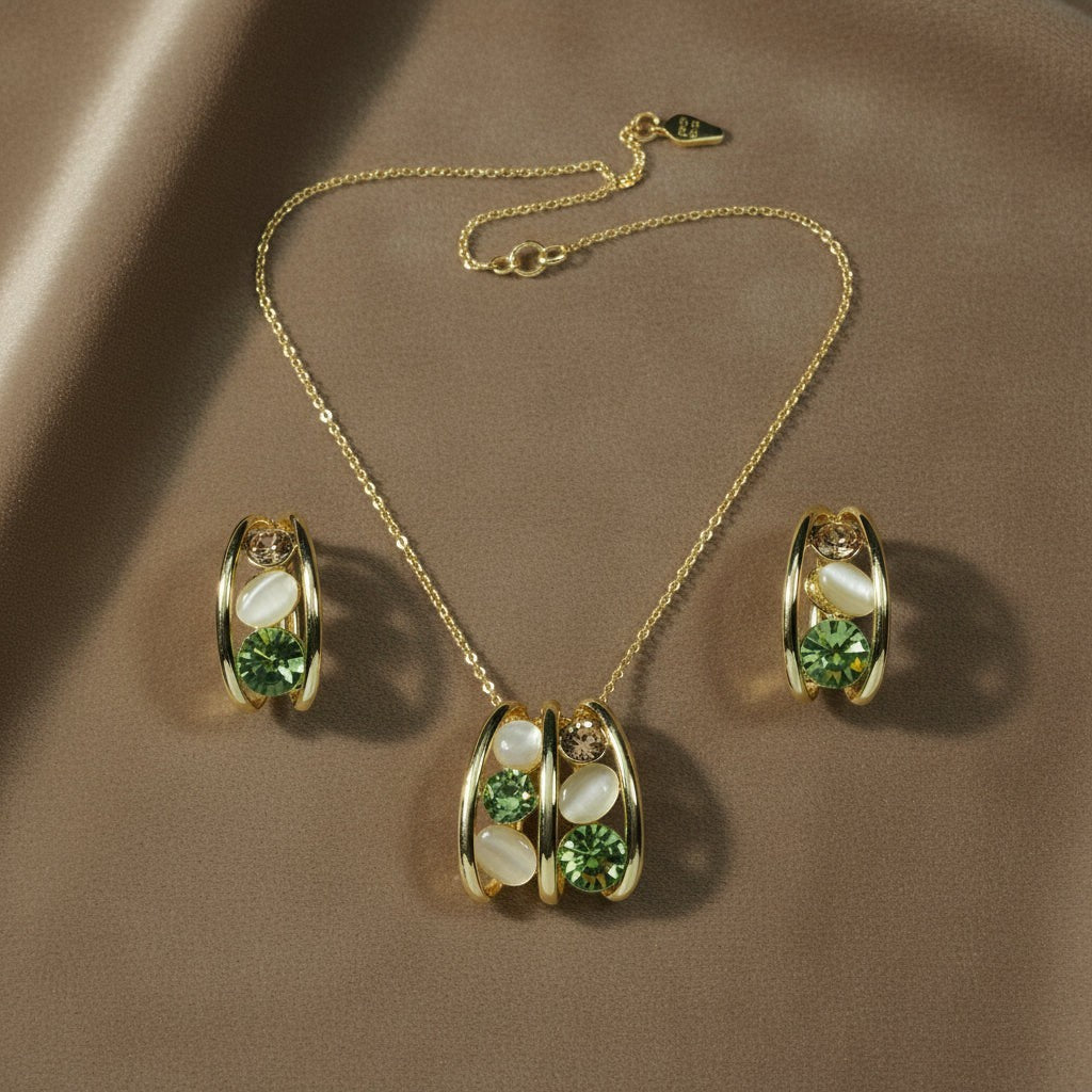 SVORA gold tone necklace and earrings set with emerald green crystals and cream cabochons in a caged design.
