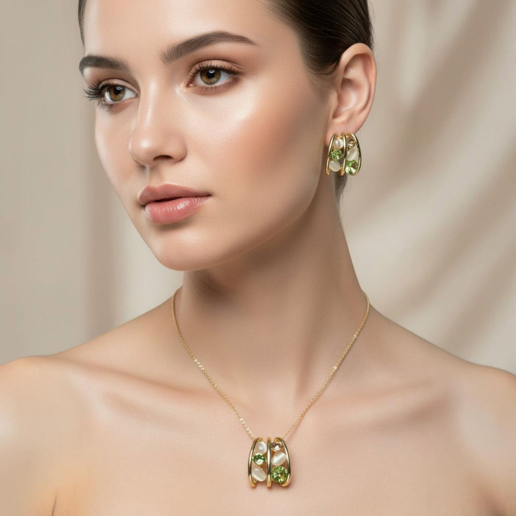 SVORA gold tone necklace and earrings set with emerald green crystals and cream cabochons in a caged design.