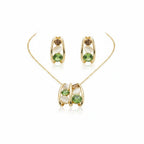 SVORA gold tone necklace and earrings set with green crystal, peach, and cream cabochon stones in a caged design.