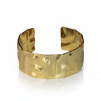 SVORA wide hammered gold cuff bracelet made of 18K gold plated stainless steel. Adjustable and waterproof.