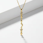 SVORA gold plated stainless steel necklace with a vertical drop of hamsa, star, moon, and eye charms.