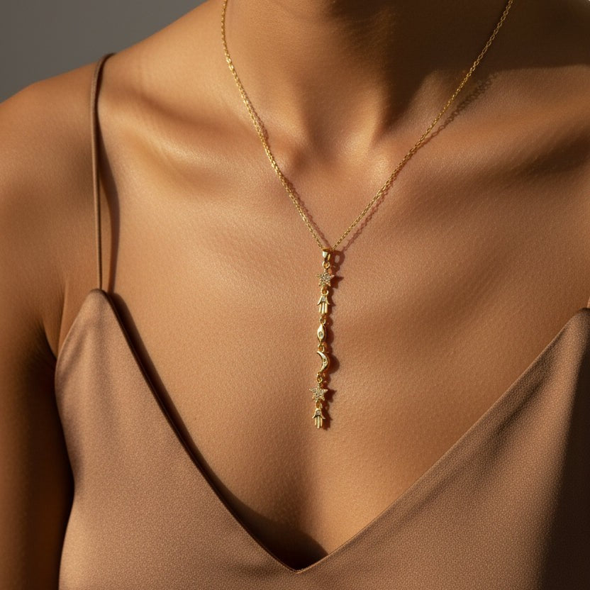 SVORA gold plated stainless steel Hamsa Talisman Charm Necklace with star, moon, and eye charms.