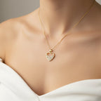 SVORA gold plated stainless steel half heart pendant necklace with baguette CZ stones.