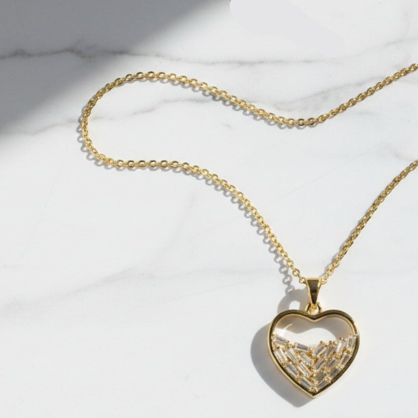 SVORA gold plated stainless steel necklace with a heart pendant filled with baguette-cut cubic zirconia stones.