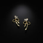 SVORA gold-tone stainless steel dangle earrings with crystal heart tops and bow drops. Elegant and sparkly.