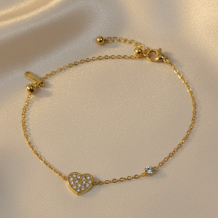 SVORA gold-plated stainless steel bracelet with a pavé CZ heart charm and a round stone accent. Adjustable.