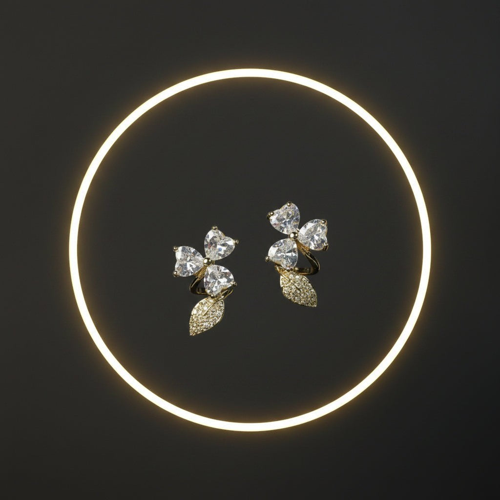 SVORA gold tone stainless steel stud earrings with pavé heart petals and leaf accents, adorned with cubic zirconia.