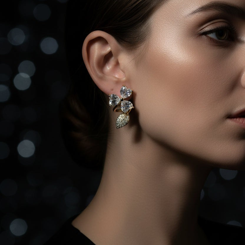 SVORA gold-tone stainless steel stud earrings with pavé heart flowers and leaf accent, adorned with cubic zirconia.