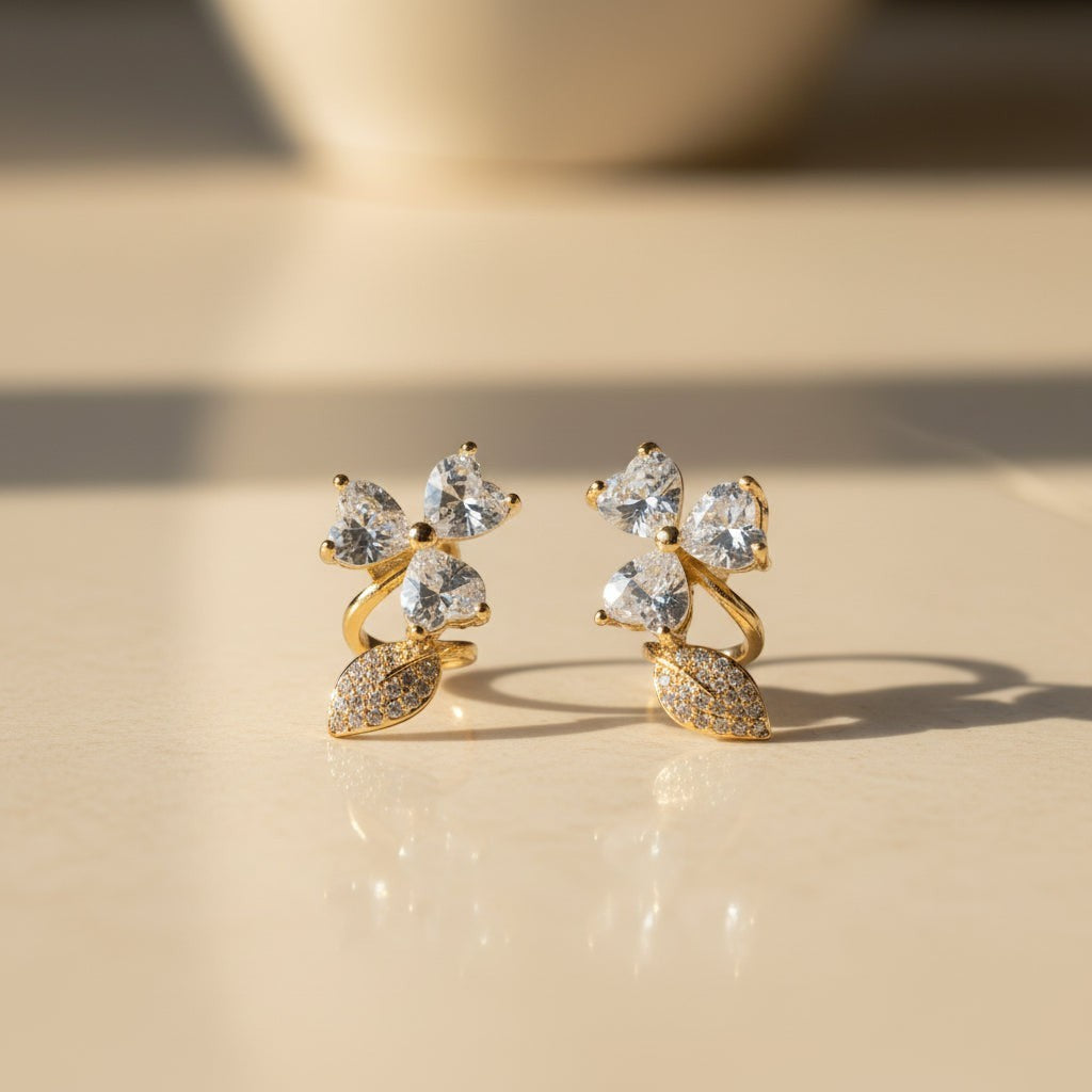 SVORA gold-tone stainless steel stud earrings with pavé heart petals and leaf accents, adorned with cubic zirconia.