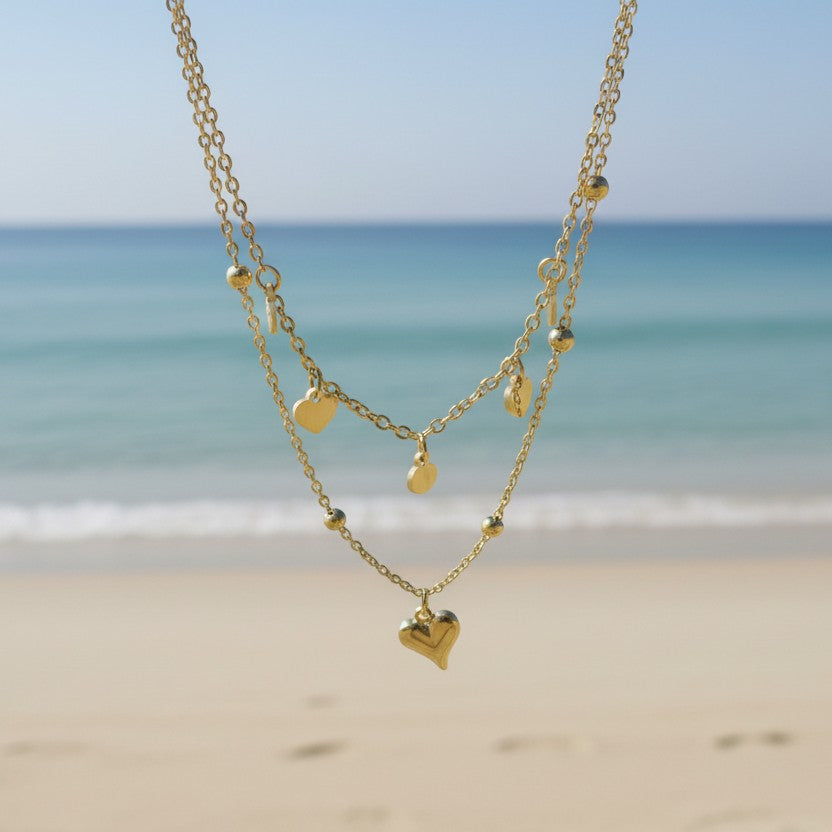 SVORA gold layered necklace with heart and disc charms, made of stainless steel with 18k gold plating.